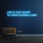 Bold 'Life Is Too Short To Drive Boring Cars' neon sign, perfect for car enthusiasts and garage decor.