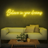 Believe in Your Dreams LED neon sign in yellow, adding a warm glow to a modern living room