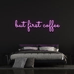 Purple "But First Coffee" LED neon sign elegantly placed above a stylish bed with a dark wall background, ideal for coffee enthusiasts.