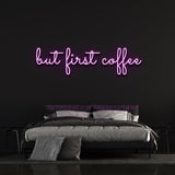 Purple "But First Coffee" LED neon sign elegantly placed above a stylish bed with a dark wall background, ideal for coffee enthusiasts.