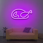 Chicken LED neon sign with a purple glow, mounted on a wall in a cozy living room setup, perfect for decorative and functional lighting.