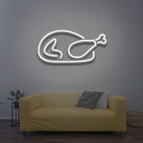 Chicken LED neon sign glowing in white color, placed on a gray wall above a yellow couch, suitable for modern living room and cafe lighting.
