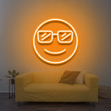 Cool LED Neon Sign featuring a smiling face with sunglasses, glowing yellow above a yellow couch, adding vibrant and fun decor to the room.