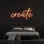 Modern neon 'create' sign illuminating a stylish bedroom with dark walls and contemporary bedding.