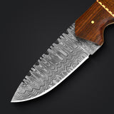 Close-up of a Damascus steel hunting knife blade with intricate wave patterns, highlighting premium craftsmanship.