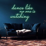 Green neon sign reading "Dance like no one is watching" mounted on a dark blue wall above a modern couch. Ideal for home decor or party lighting.