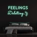 Deleting Feelings neon sign with green light, stylish bedroom wall decor and unique lighting idea.