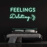Deleting Feelings neon sign with green light, stylish bedroom wall decor and unique lighting idea.