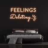 Deleting Feelings neon sign with orange light, perfect for modern bedroom decor and emotional wall art.