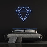 Blue diamond-shaped LED neon sign on black wall in trendy bedroom with bed and pillows.