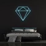Light blue diamond-shaped LED neon sign on black wall in modern bedroom with bed and pillows.