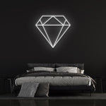  White diamond-shaped LED neon sign on black wall in contemporary bedroom with bed and pillows.