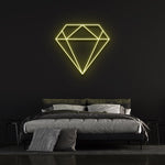 Yellow diamond-shaped LED neon sign on black wall in elegant bedroom with bed and pillows.