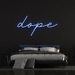 Dope LED neon sign glowing in blue, enhancing the ambiance of a sleek and modern bedroom with dark walls.