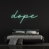 Dope LED neon sign in green color adding a unique touch to a black-walled bedroom with contemporary design.