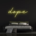 Dope LED neon sign in yellow, bringing a warm and trendy vibe to a bedroom with black walls and stylish decor.