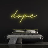 Dope LED neon sign in yellow, bringing a warm and trendy vibe to a bedroom with black walls and stylish decor.
