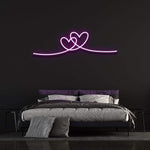 Double heart purple neon wall sign adding romantic vibes to bedroom decor.
