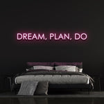 Pink "Dream, Plan, Do" LED neon sign in a modern bedroom setup.