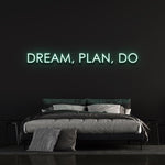 Warm white "Dream, Plan, Do" LED neon sign adding subtle bedroom lighting.