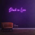 Drunk in Love purple LED neon sign as trendy wall decor for bedroom spaces.