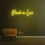 Drunk in Love yellow LED neon sign as modern wall decor for home and living spaces.