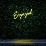 Engaged yellow neon sign for event lighting, enhancing celebrations with warm glow.