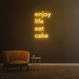 Enjoy Life Eat Cake yellow neon LED sign for vibrant interior decoration, suitable for kitchens and bakeries.