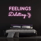 Pink "Feelings Deleting" neon sign mounted on a black wall, enhancing the aesthetic of a contemporary bedroom setting.