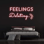 Red "Feelings Deleting" neon sign lighting up a stylish bedroom with a sleek and modern design.
