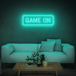 Seegreen GAME ON LED neon sign with modern white couch and a coffee table in the room.