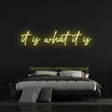It Is What It Is LED Neon Sign in cheerful yellow, trendy and energy-efficient wall decor ideal for elevating home or office ambiance.