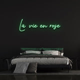 La Vie En Rose LED Neon Sign with green light accent, offering elegant cursive design perfect for home, office, or events decor.