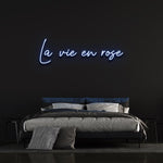La Vie En Rose LED Neon Sign with a calming light blue glow, perfect for bedrooms or creating an elegant ambiance in your home.