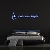 La Vie En Rose LED Neon Sign with a calming light blue glow, perfect for bedrooms or creating an elegant ambiance in your home.