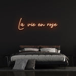 La Vie En Rose LED Neon Sign with vibrant orange light, creating a warm and welcoming atmosphere for your home or special event.