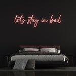 Cozy 'Let's Stay in Bed' LED neon sign for a relaxed and inviting bedroom ambiance.