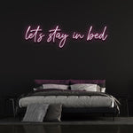 Upgrade your bedroom decor with the eco-friendly 'Let's Stay in Bed' LED neon sign.