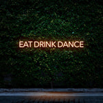 Orange LED neon sign reading Eat Drink Dance for event decor and hospitality spaces.