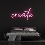 Pink neon 'Create' sign glowing on a dark wall above a modern bedroom setup, perfect for creative and inspiring decor.