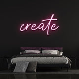 Pink neon 'Create' sign glowing on a dark wall above a modern bedroom setup, perfect for creative and inspiring decor.
