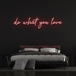 Red 'Do What You Love' neon sign glowing in a cozy bedroom
