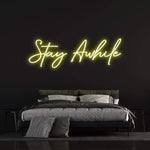 Stay Awhile LED Neon Sign for home or office decor, emitting a warm, soft glow to create a peaceful ambiance.