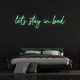 Add a playful touch to your bedroom with the 'Let's Stay in Bed' LED neon sign.