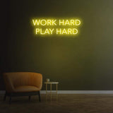 Work Hard Play Hard neon sign in lemon yellow light, perfect for inspiring office decor or modern home aesthetics.