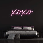 XOXO LED neon sign in vibrant pink light, perfect for bedroom decor and romantic ambiance.