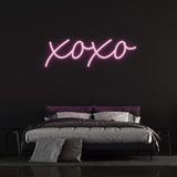 XOXO LED neon sign in vibrant pink light, perfect for bedroom decor and romantic ambiance.