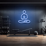 Yoga icon LED neon sign in blue light, wall decor for gym or fitness room with modern workout equipment, perfect for gym lighting aesthetics.
